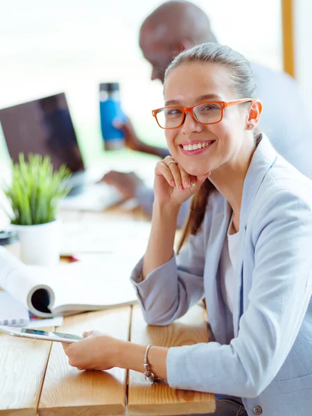 Business woman sitting in her office using a tablet computer — Stock Photo, Image