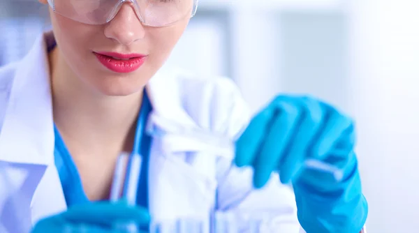 Woman researcher is surrounded by medical vials and flasks, isolated on white background — Stock Photo, Image