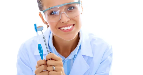 Bela dentista feminina segurando e mostrando uma escova de dentes isolada em um fundo branco — Fotografia de Stock