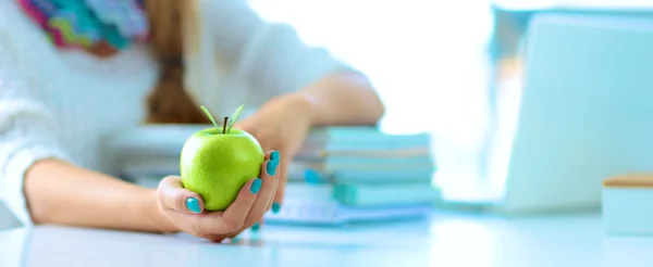 Estudiantes universitarias sentadas en el escritorio con manzana en un montón de libros —  Fotos de Stock