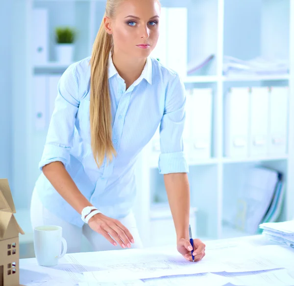 Retrato de una arquitecta con planos en el escritorio en la oficina — Foto de Stock