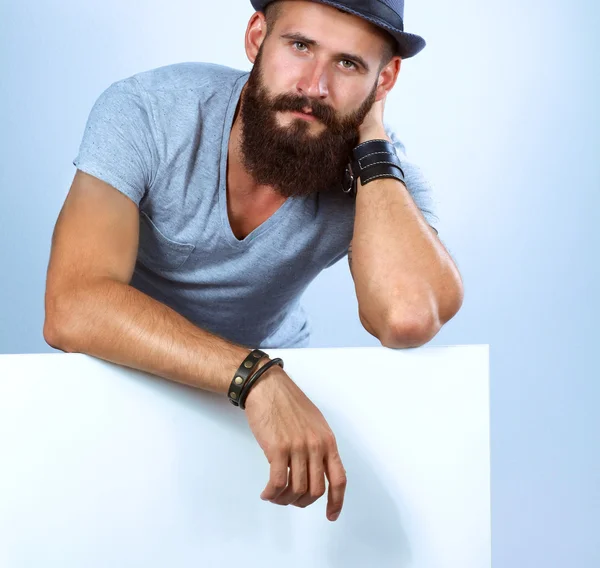 Portrait of young man in hat standing near blank, isolated on white background — Stock Photo, Image