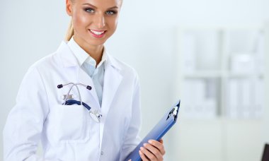 Hastanede üniformalı, gülümseyen bir kadın doktor.