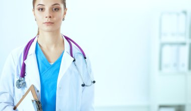 Kadın doktor hastanede dosyayla bekliyor.