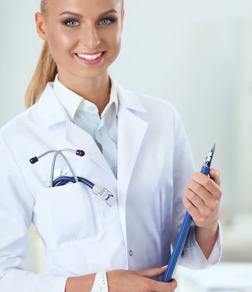 Lächelnde Ärztin mit Ordner in Uniform steht im Krankenhaus — Stockfoto