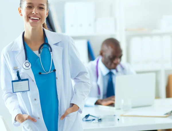 Una dottoressa sorridente con una cartella in uniforme all'interno — Foto Stock