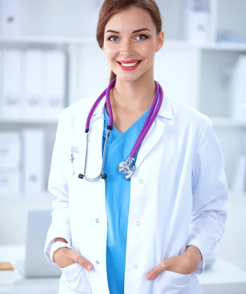 Portret van een jonge vrouwelijke arts met witte jas in het ziekenhuis — Stockfoto