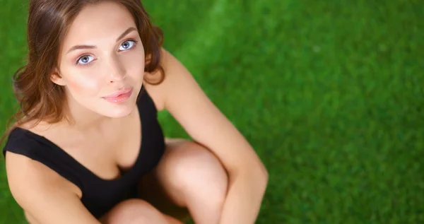 Vrouw zitten met gekruiste benen op het groene gras — Stockfoto