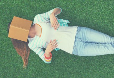 güzel bir genç kadın yeşil çim üzerinde yalan