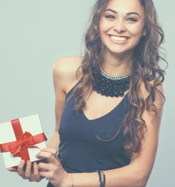 genç kadın mutlu gülümseme hediye kutusu gri arka plan üzerinde izole elinde tut