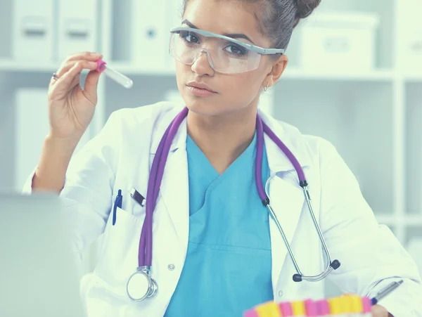 Woman researcher is surrounded by medical vials and flasks, isolated on white background — Stock Photo, Image