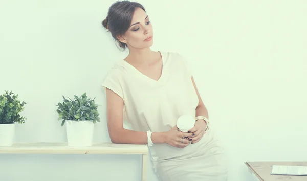 Attraktive Geschäftsfrau steht an Wand im Büro — Stockfoto