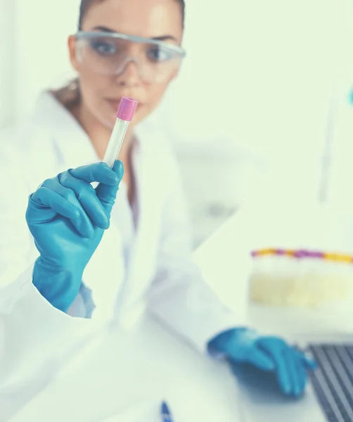 Woman researcher is surrounded by medical vials and flasks, isolated on white background — Stock Photo, Image