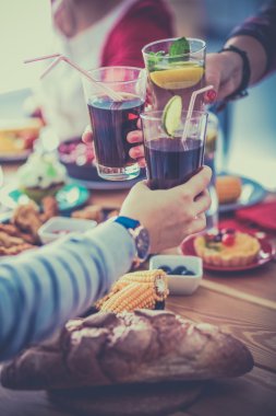 Yemek masasında içki içen insanlar.