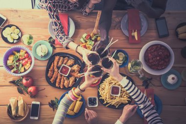 Yemek masasında içki içen insanlar.