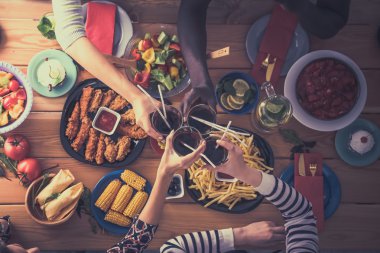 Yemek masasında içki içen insanlar.