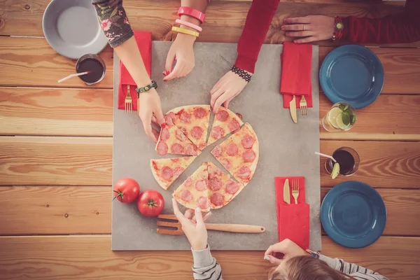 Group of people eating pizza.