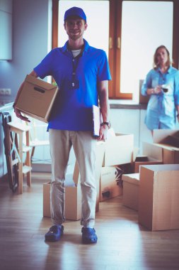 Mavi üniformalı gülümseyen kurye servis konseptine paket kutusu teslim eden teslimatçı. Mavi üniformalı gülümseyen teslimatçı.