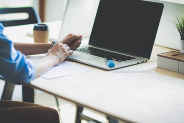 Ofis masasında dizüstü bilgisayarla oturan genç bir kadın. Genç bir kadın. Dizüstü bilgisayar