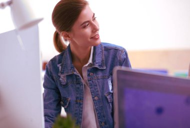 Masanın yanında duran iki genç kadın enstrüman, plan ve dizüstü bilgisayarla.