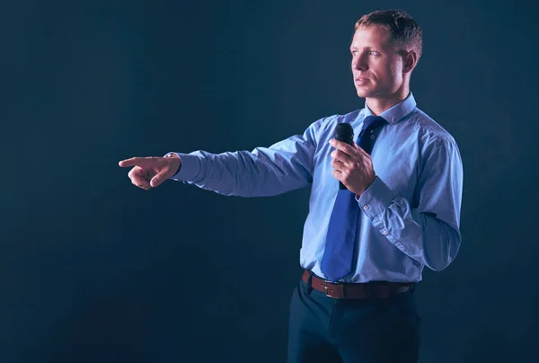 Man holding a microphone while pointing his finger at you — Stock Photo, Image