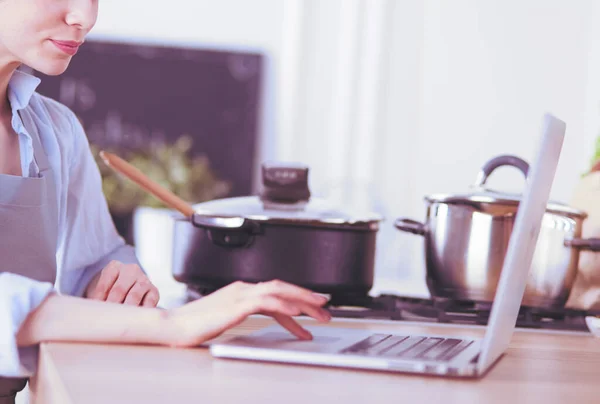 Fiatal nő használ egy tabletta számítógép főzni a konyhában. — Stock Fotó