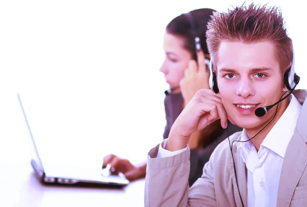 Friendly customer service consultants working, focus on a young man — Stock Photo, Image