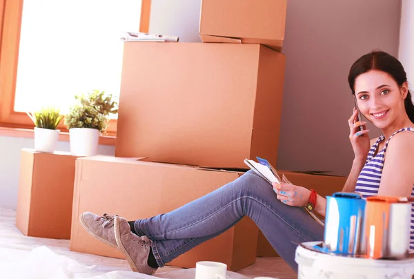 Woman in a new home with cardboard boxes — Stock Photo, Image