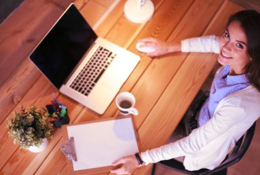 Masasında oturan ve elinde bir fincan kahveyle rahatlamış genç bir kadının portresi. İş kadını. İşyeri