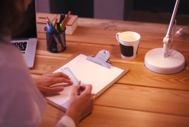 Masada oturan genç bir kadın.