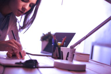 Masada oturan genç bir kadın.