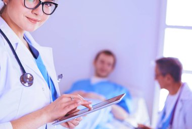 Hastane lobisinde tablet bilgisayar kullanan kadın doktor.