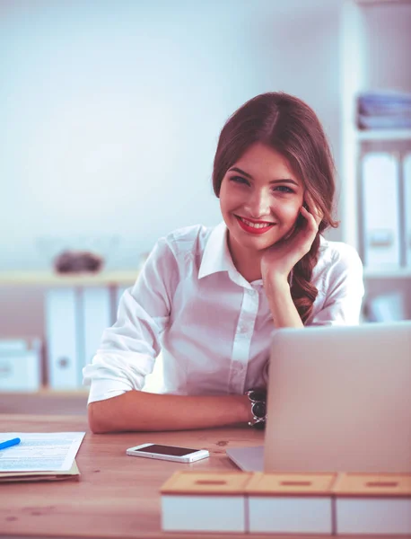 Empresária atraente sentada na mesa no escritório — Fotografia de Stock