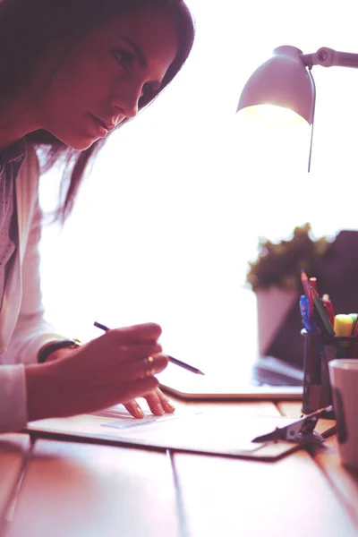 Giovane donna seduta ad una scrivania. Una donna d'affari. Disegno. Studente. Posto di lavoro. Scrivania. — Foto Stock