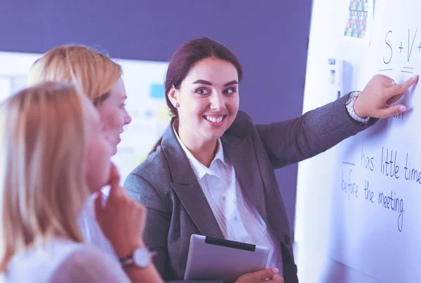 Business, education and office concept - business team with flip board in office discussing something. — Stock Photo, Image