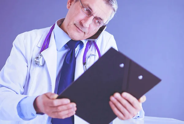 Male doctor writes notes on the clipboard in the hospital — Stock Photo, Image