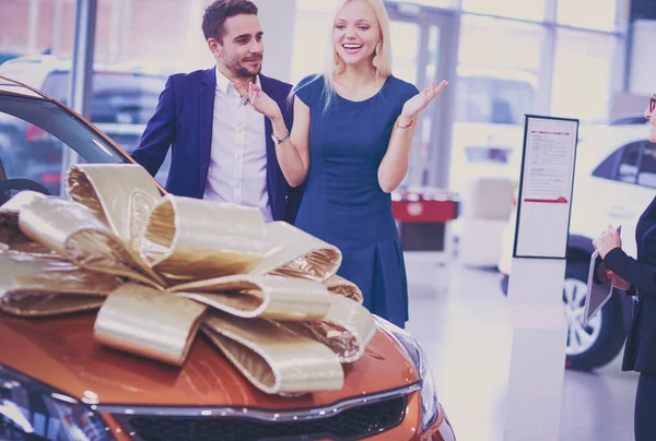 Un homme fait un cadeau - une voiture à sa femme. Elle est surprise de cela. Ils sont très heureux à ce sujet — Photo