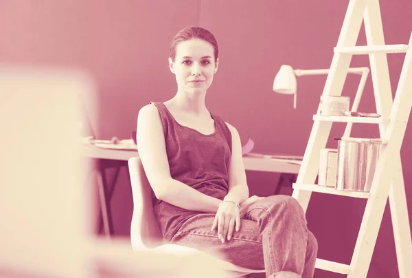 Mujer joven sentada en el escritorio con instrumentos, plano y portátil. — Foto de Stock