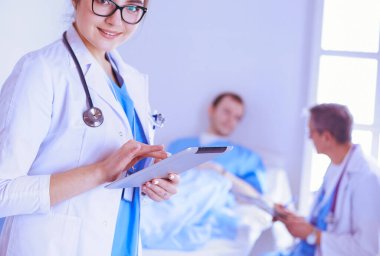 Hastane lobisinde tablet bilgisayar kullanan kadın doktor.