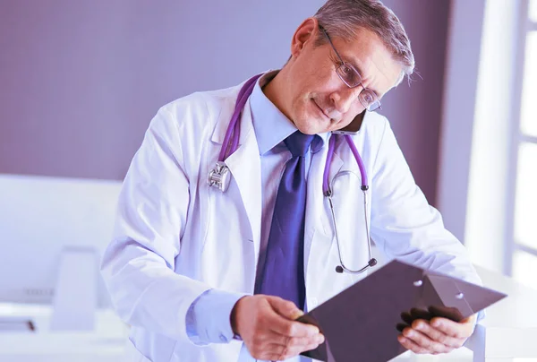 Male doctor writes notes on the clipboard in the hospital — Stock Photo, Image