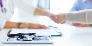 Bayan doktor ofisinde el sıkışıyor.