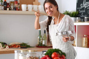 Mutfakta ahşap kaşıkla yemek pişiren kadın
