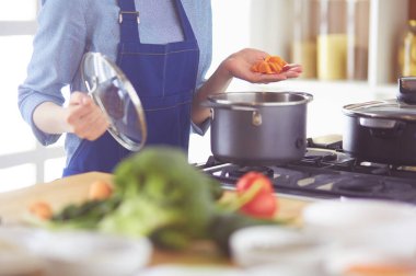 Mutfakta ahşap kaşıkla yemek pişiren kadın