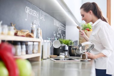 Genç kadın tableti mutfakta..