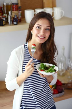 Genç bayan mutfakta masanın yanında oturuyor.