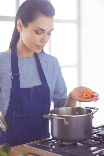 Cuisson femme dans la cuisine avec cuillère en bois — Photo