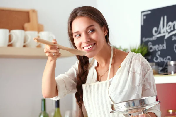 Mujer cocinera en cocina con cuchara de madera — Foto de Stock