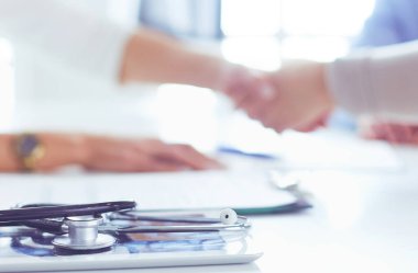 Bayan doktor ofisinde el sıkışıyor.