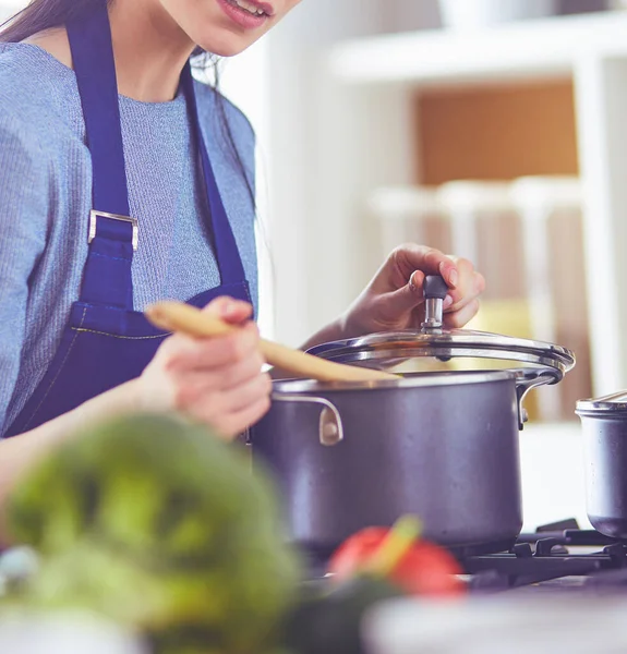 Cozinhar mulher na cozinha com colher de madeira — Fotografia de Stock