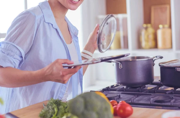 Молода жінка використовує планшетний комп'ютер для приготування їжі на кухні . — стокове фото
